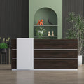 Modern reception table with dark wood finish and white accent panel in stylish office setting